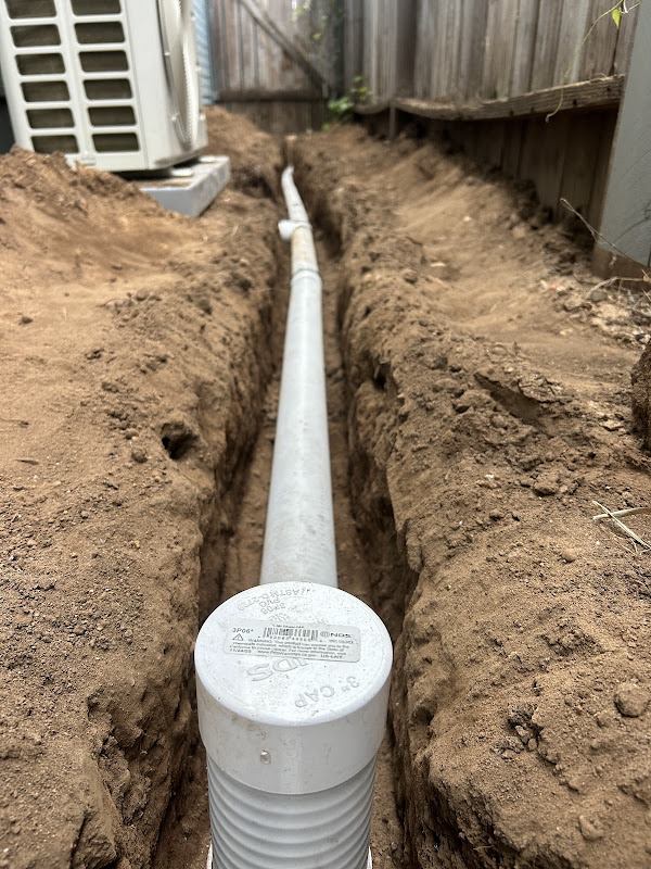 Capped PVC drain pipe laid in a trench, ready for connection