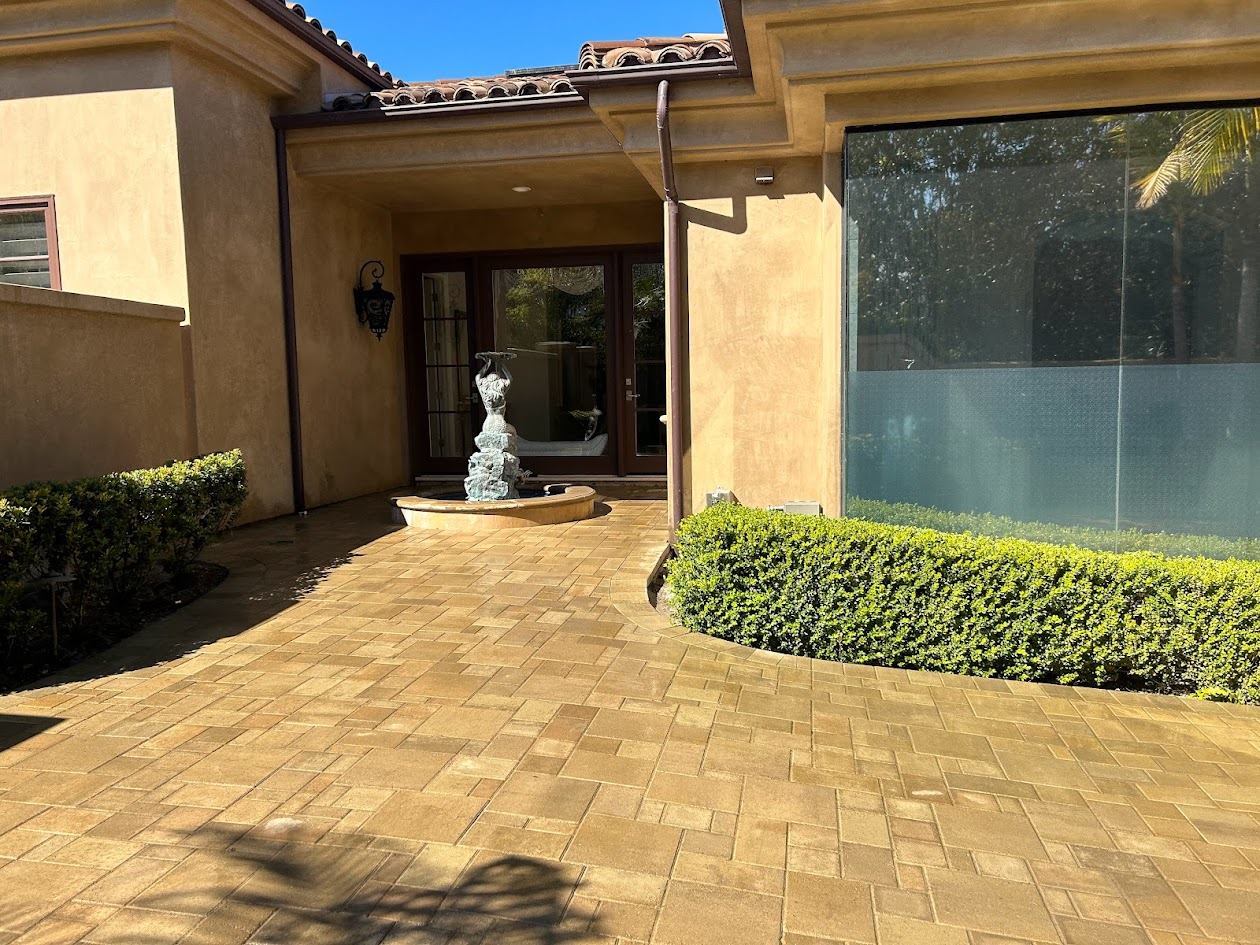 Large paver courtyard framing a stone fountain at a San Diego County estate home