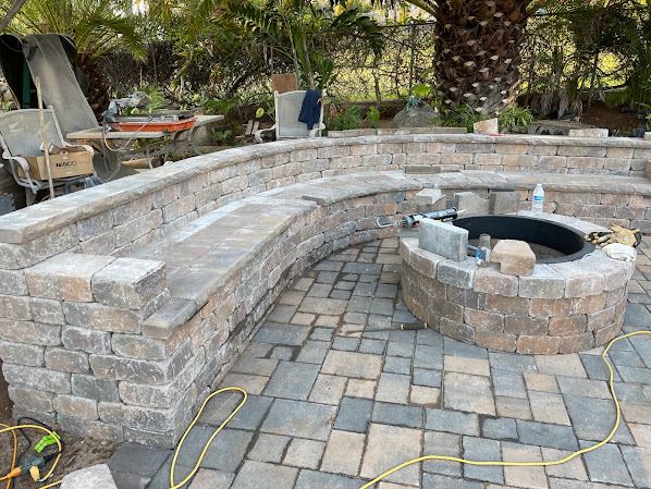 Curved stone seat wall and built-in fire pit on a new paver patio in El Cajon
