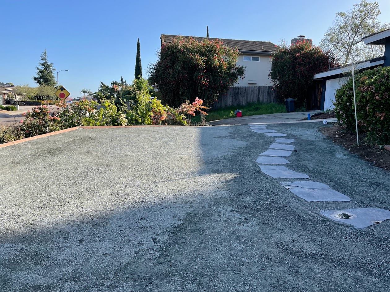 Gray DG installation with stepping stones leading toward the driveway in Clairemont