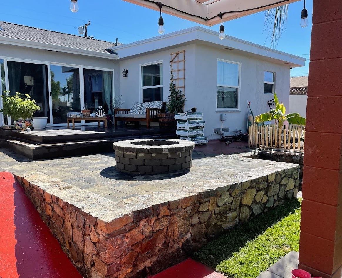 Backyard paver patio with built-in fire pit and stone seat wall in La Mesa, San Diego