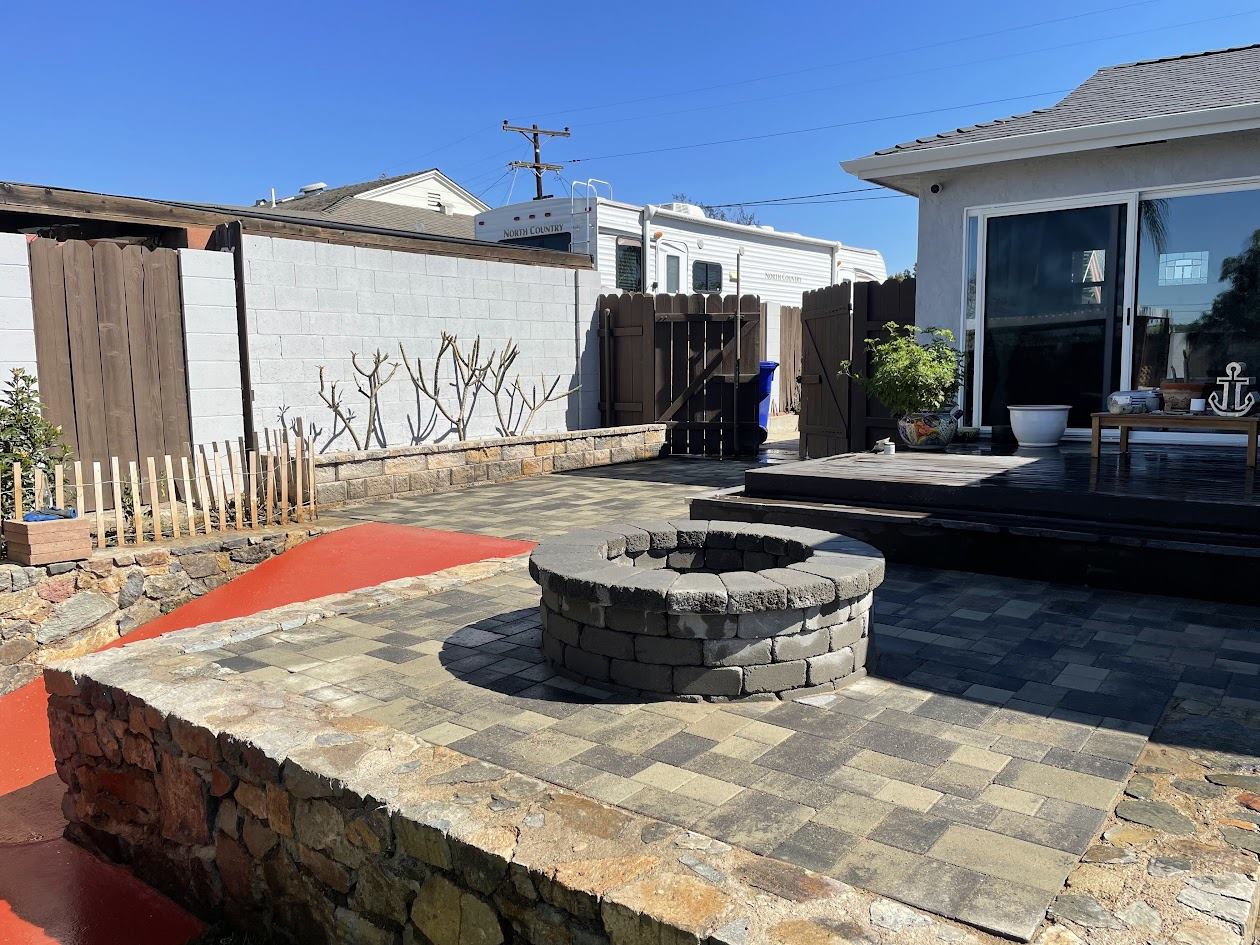 Paver patio and fire pit area connecting to the deck in a La Mesa backyard