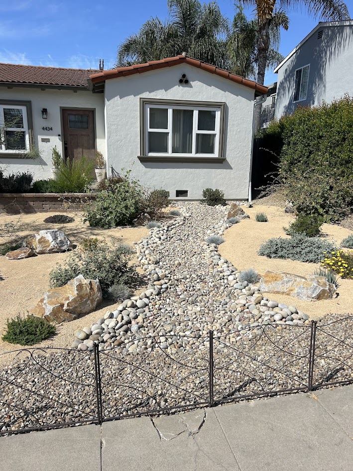 Front yard xeriscape with dry creek bed, boulders, and drought-tolerant planting in San Diego
