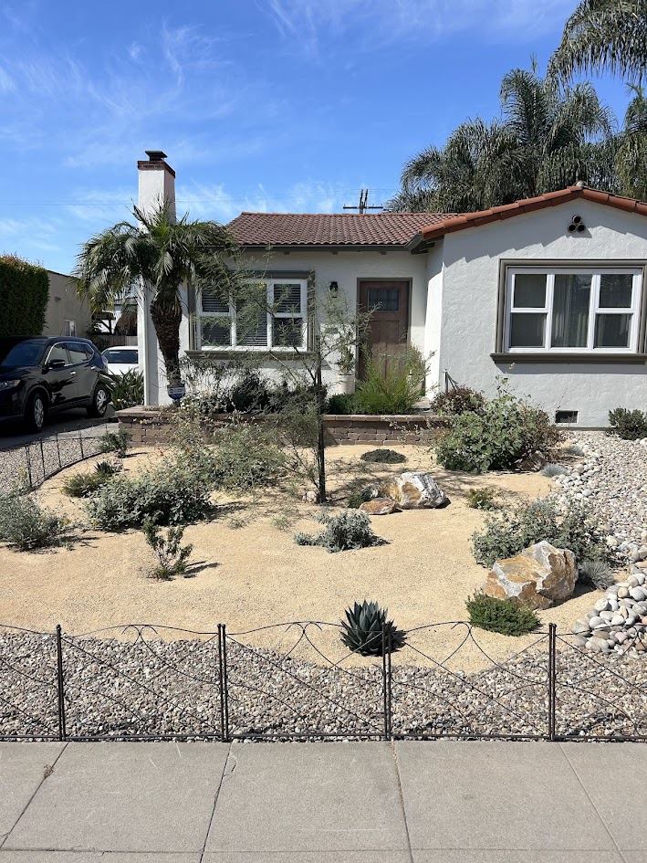 Drought-tolerant front yard with boulders, agave, and gravel groundcover in San Diego